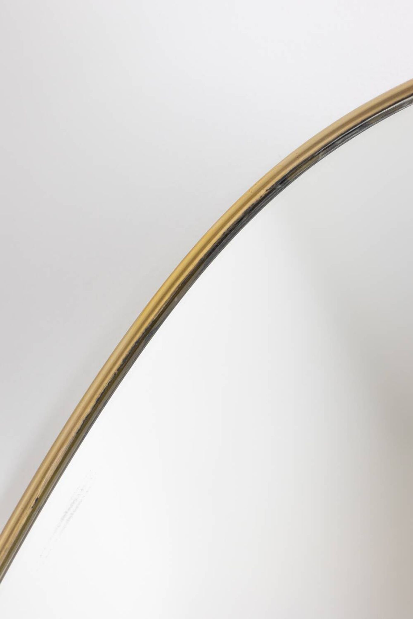 Oval shaped mirror set with a gilded brass rod. 1970s.