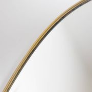 Oval shaped mirror set with a gilded brass rod. 1970s.