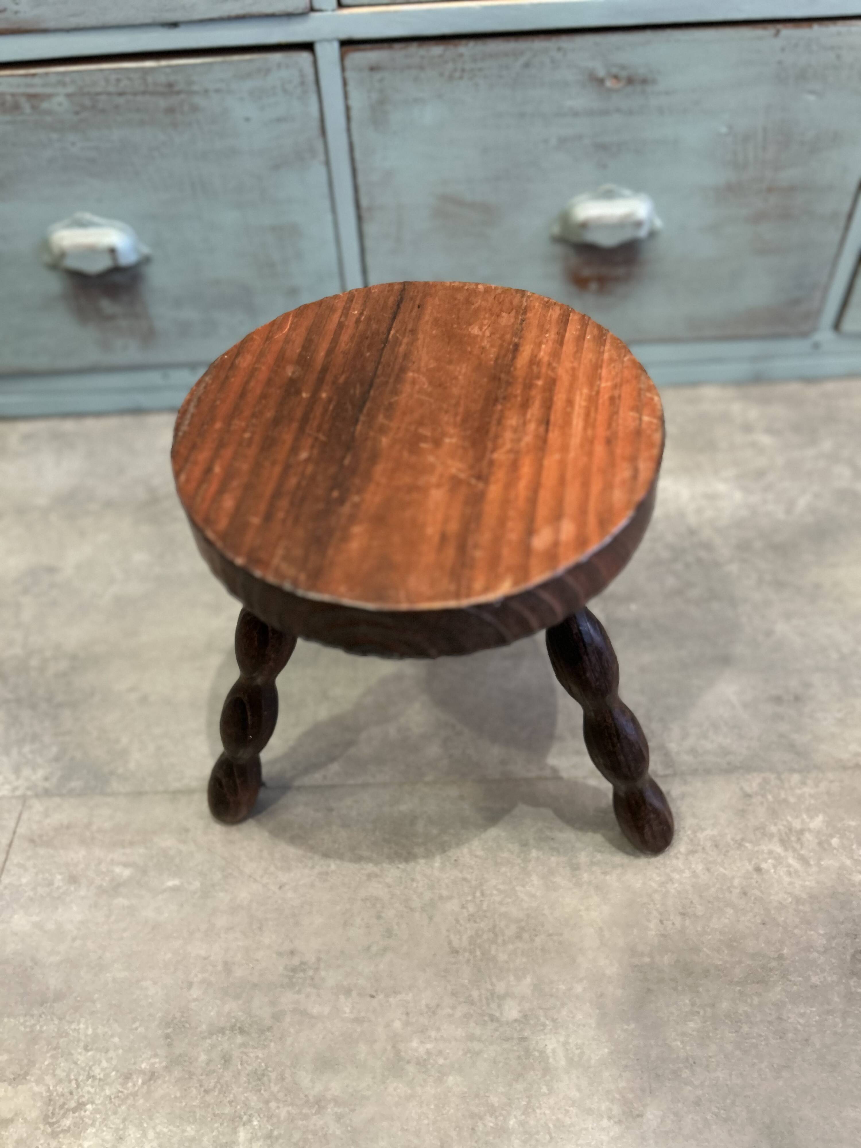 Three-legged stool with beaded wooden legs