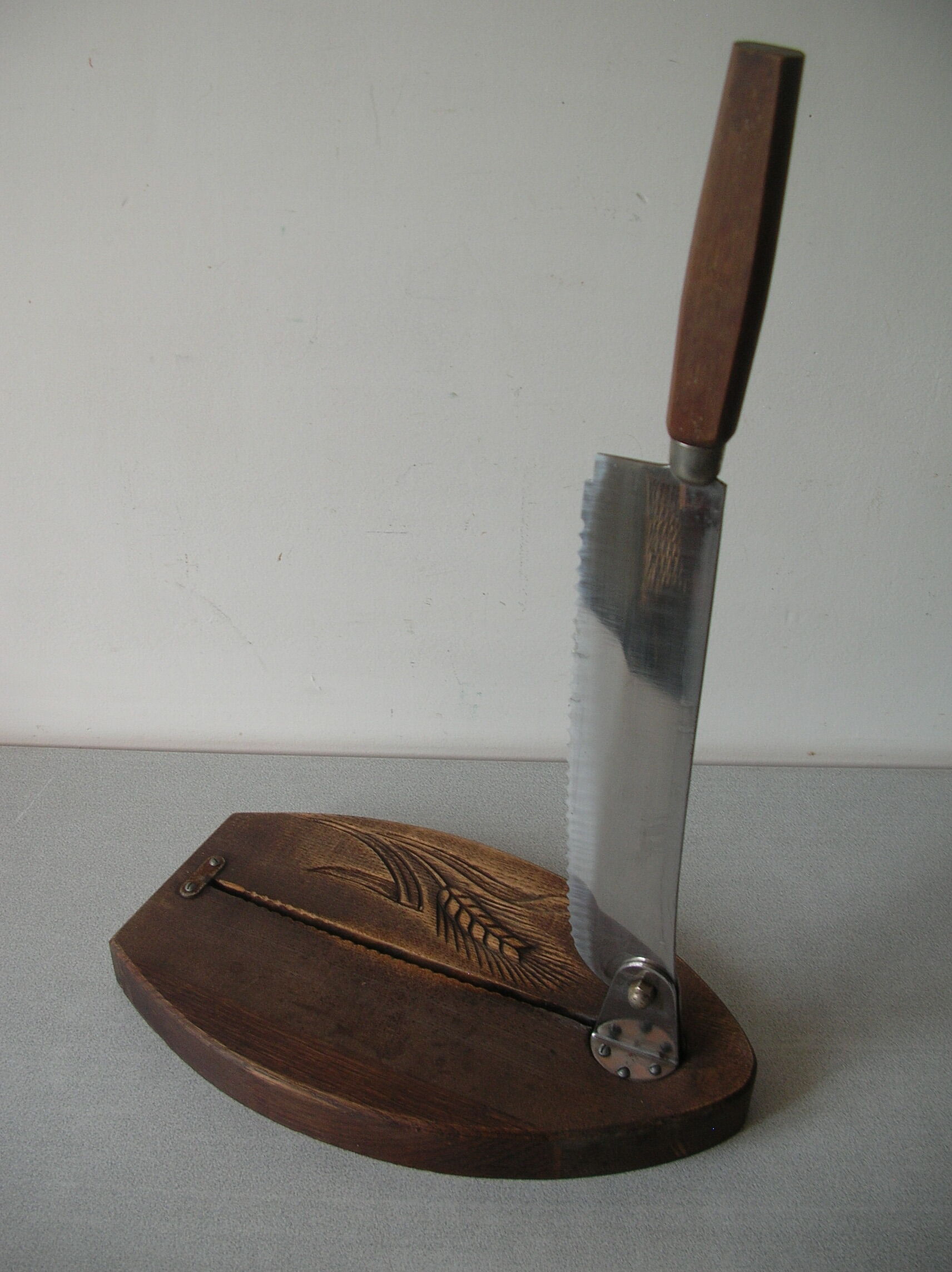 Old wooden bread cutter carved sheaf of wheat and metal deco kitchen Normandy countryside