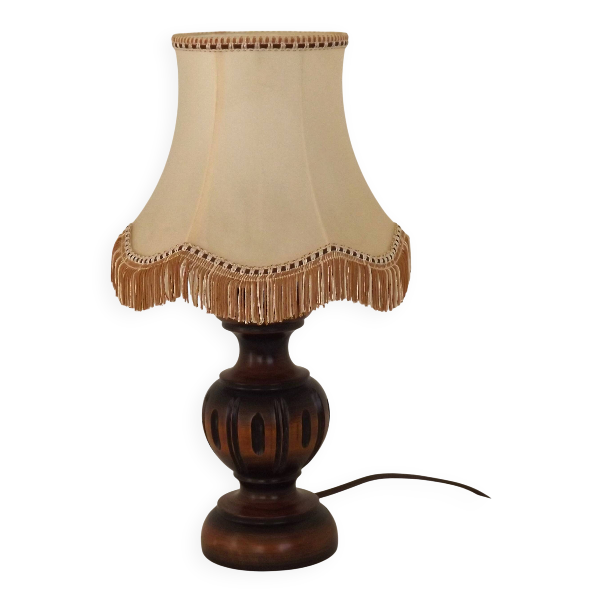 Mid-century French table lamp made of turned carved wood with a fringed shade.