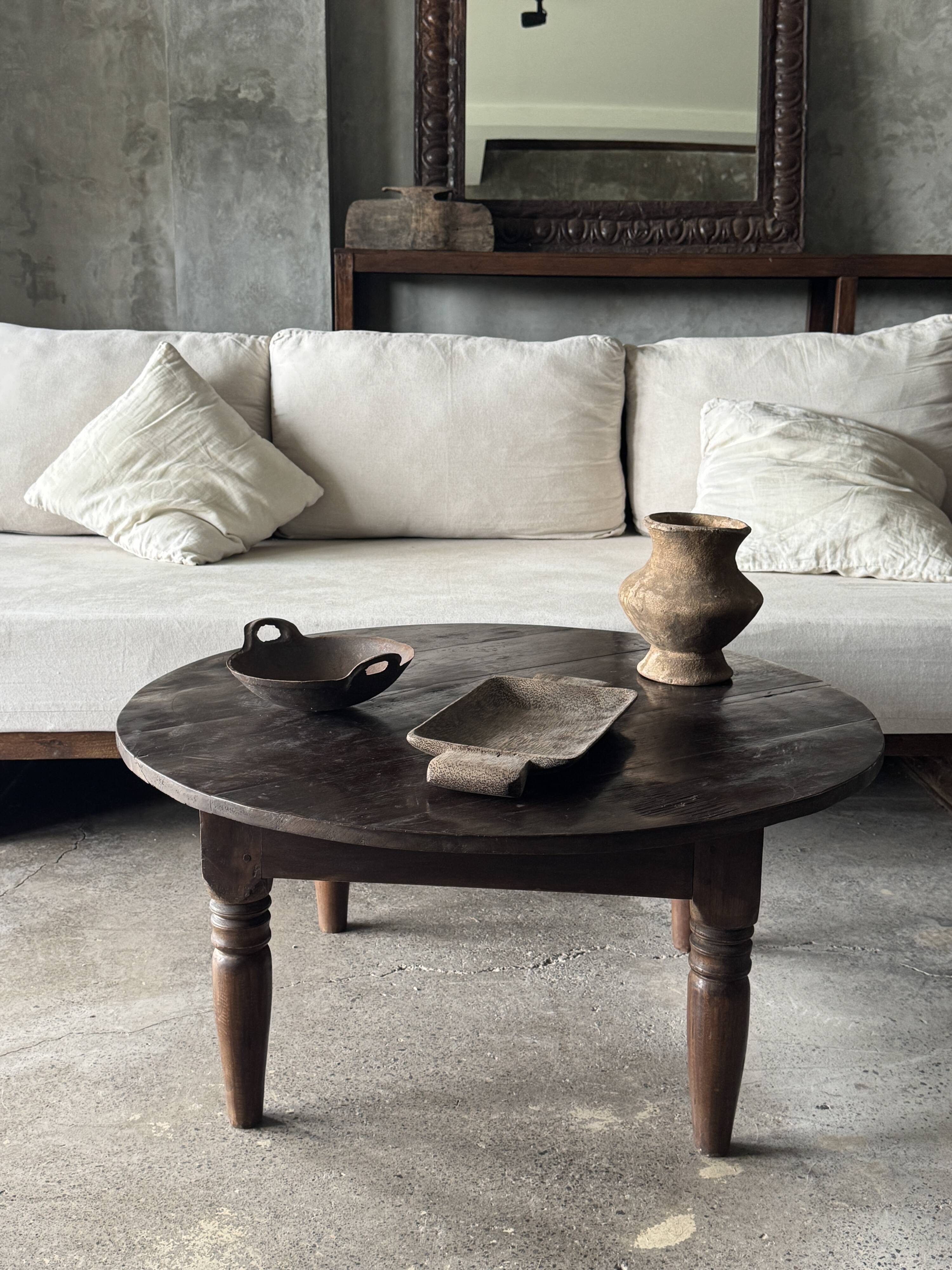 Coffee table, round antique Indonesian teak table with straight legs.