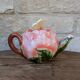 Ceramic teapot in the shape of a rose with a butterfly and raised petals.