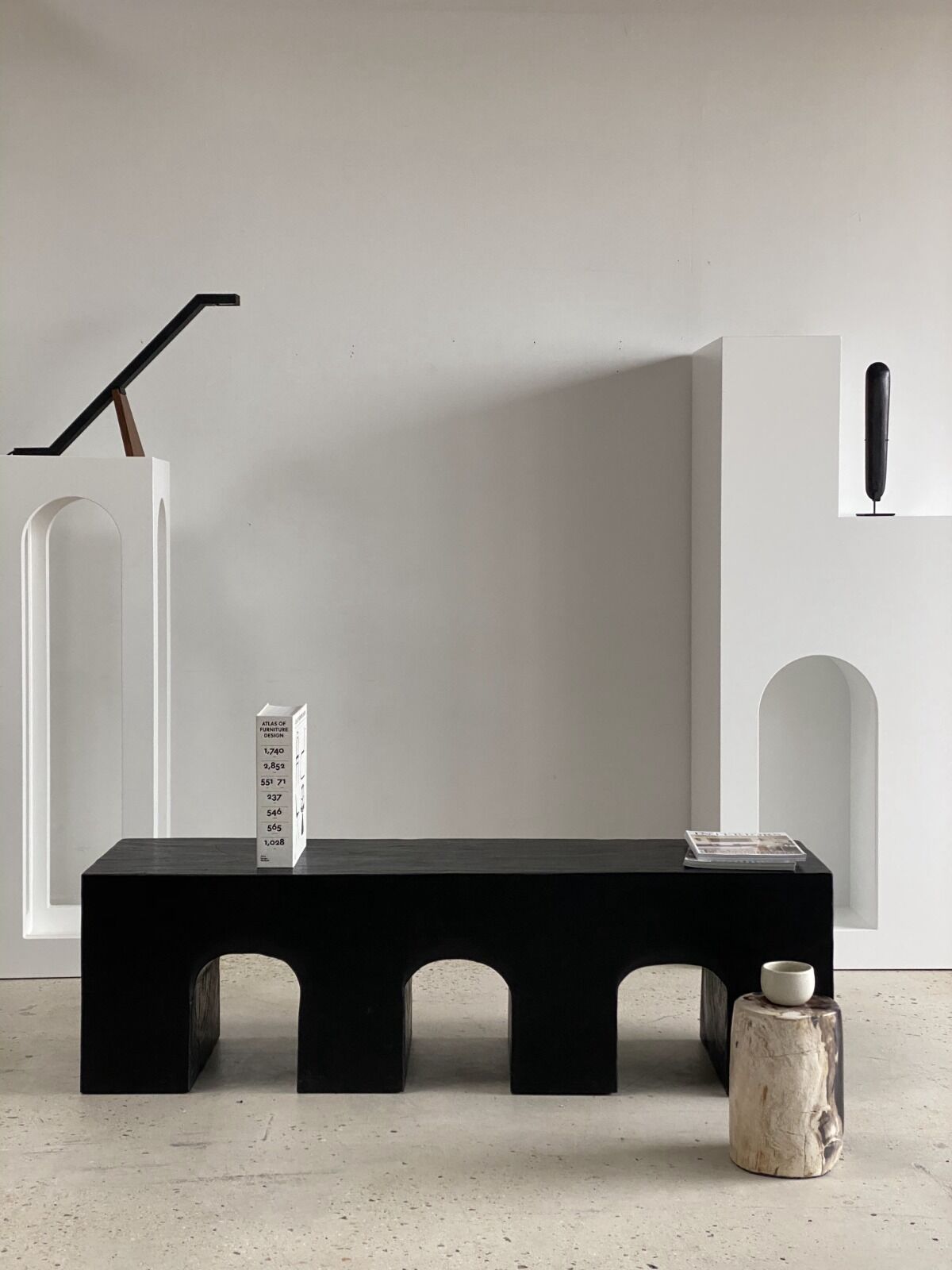 Black solid monoxyl wood bench carved into 3 arches