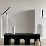 Black solid monoxyl wood bench carved into 3 arches