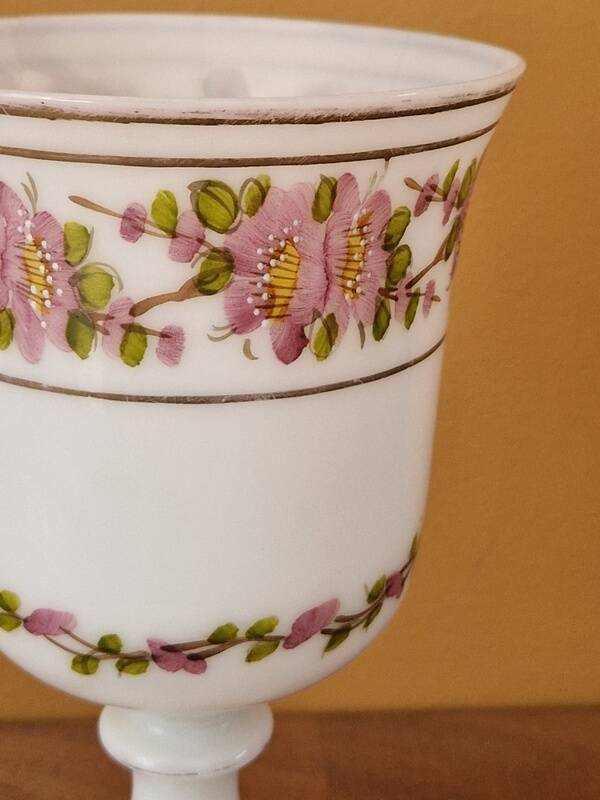 Footed glass in the shape of a chalice in white opaline with a floral decoration.