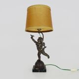 Old table lamp in repel, cherub, angel, cherub, putti with a bird in hand. 1930s