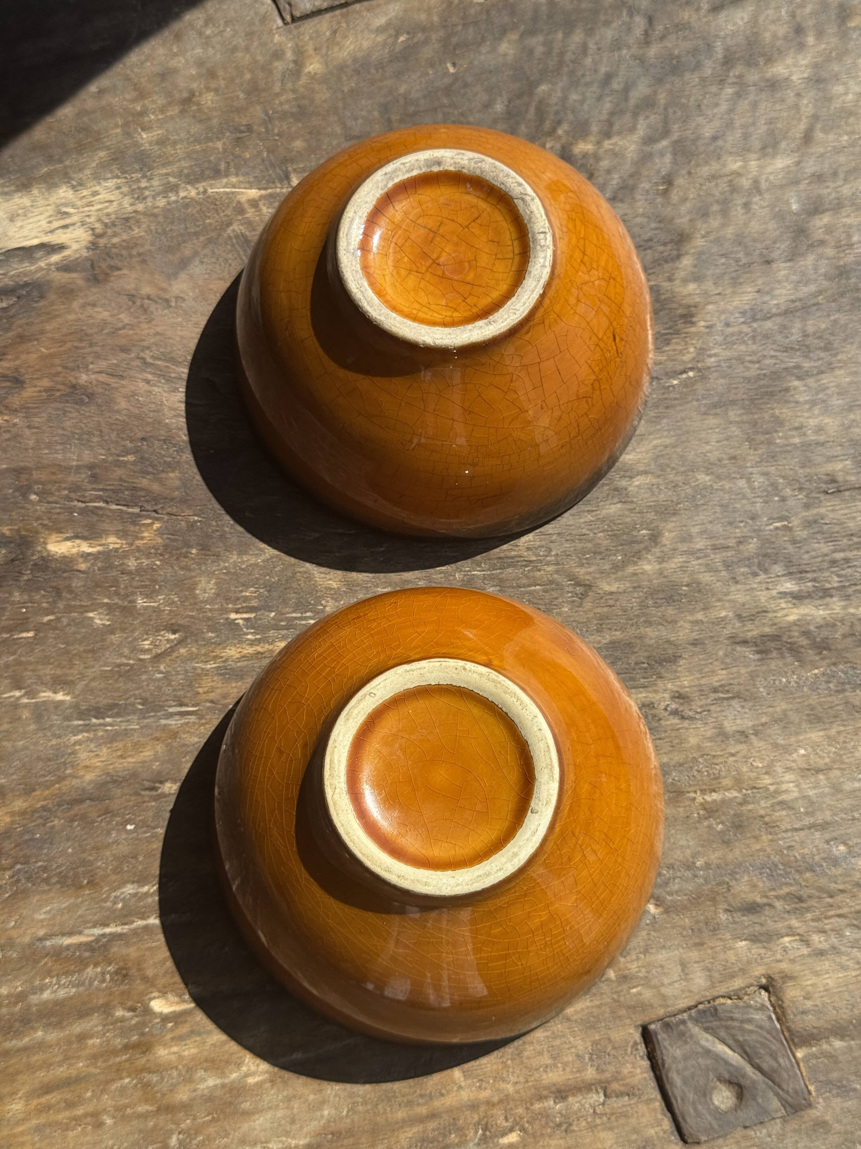 Pair of small orange bowls with black edging