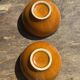 Pair of small orange bowls with black edging