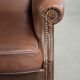 Cowhide wingback armchair in English style finished with decorative nails