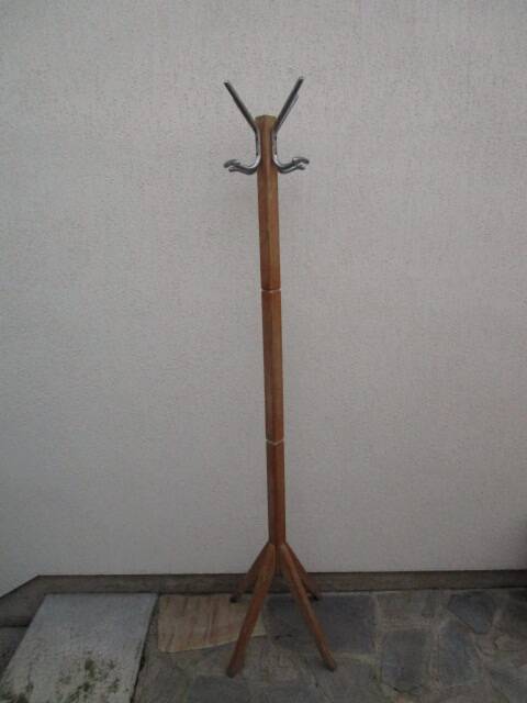Antique light wood coat rack with splayed legs.