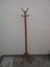 Antique light wood coat rack with splayed legs.