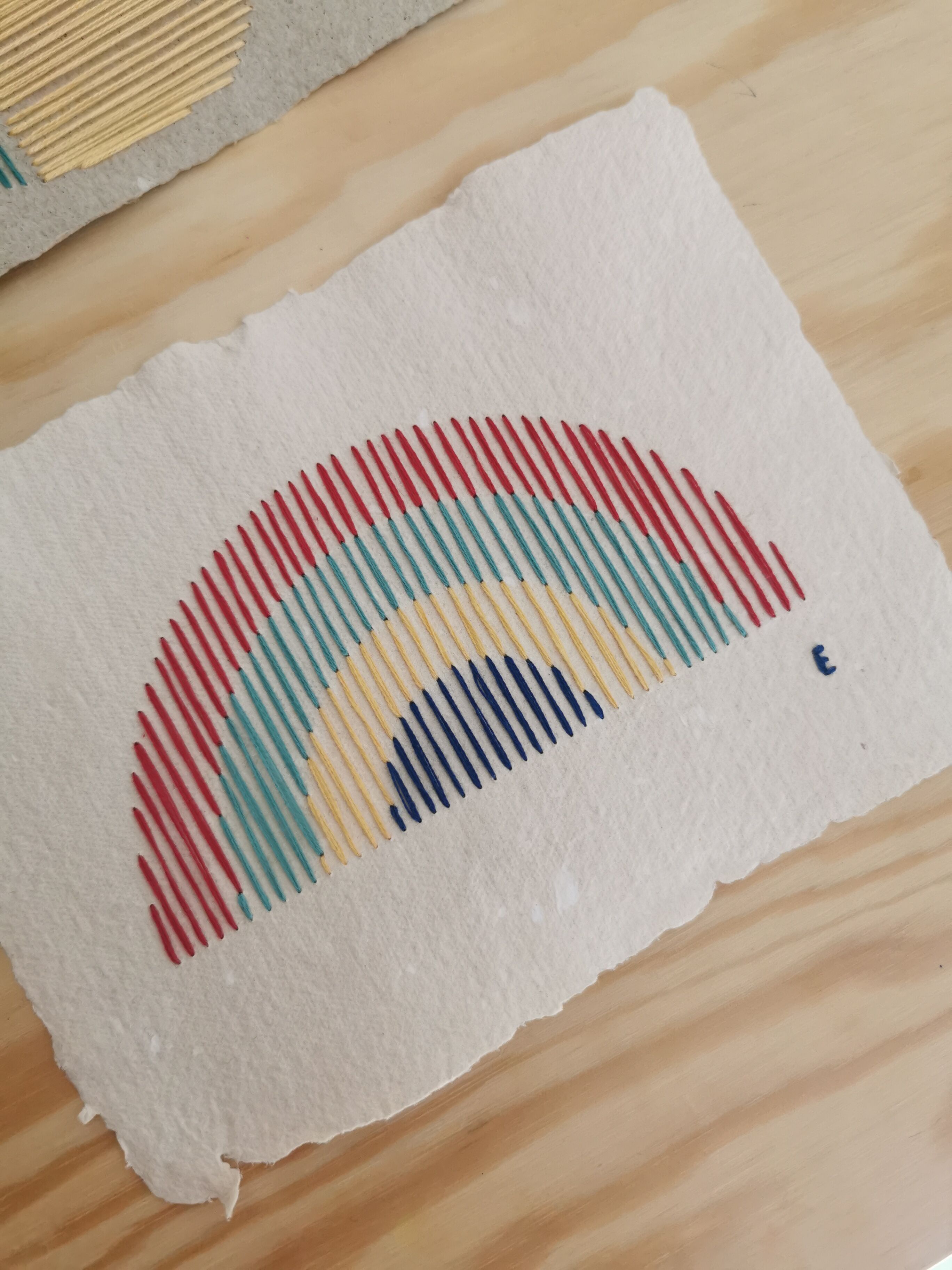 Rainbow embroidery on recycled paper