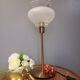 Table lamp with gold metal base and vintage white glass lampshade