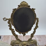 Adjustable psyche mirror of 33 centimeters in gilded bronze with angel ornament