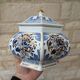 Decorative pot jar with a lid featuring a blue floral pattern and gilding.