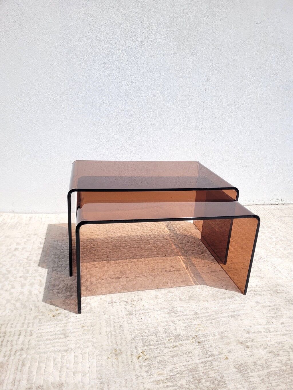 Pair of vintage smoked plexiglass nesting tables.