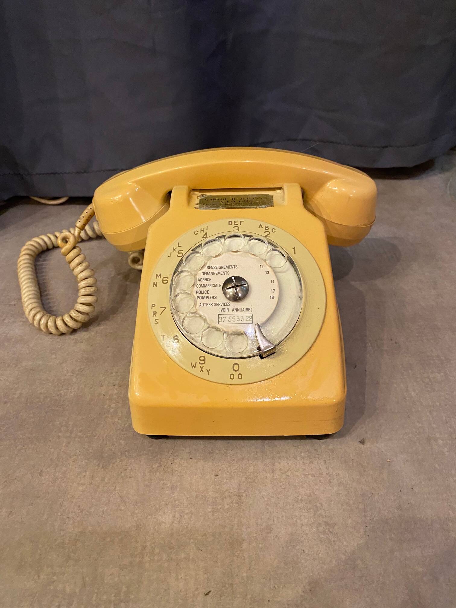 Old dial telephone from the 80s temat quimper bakelite yellow and beige