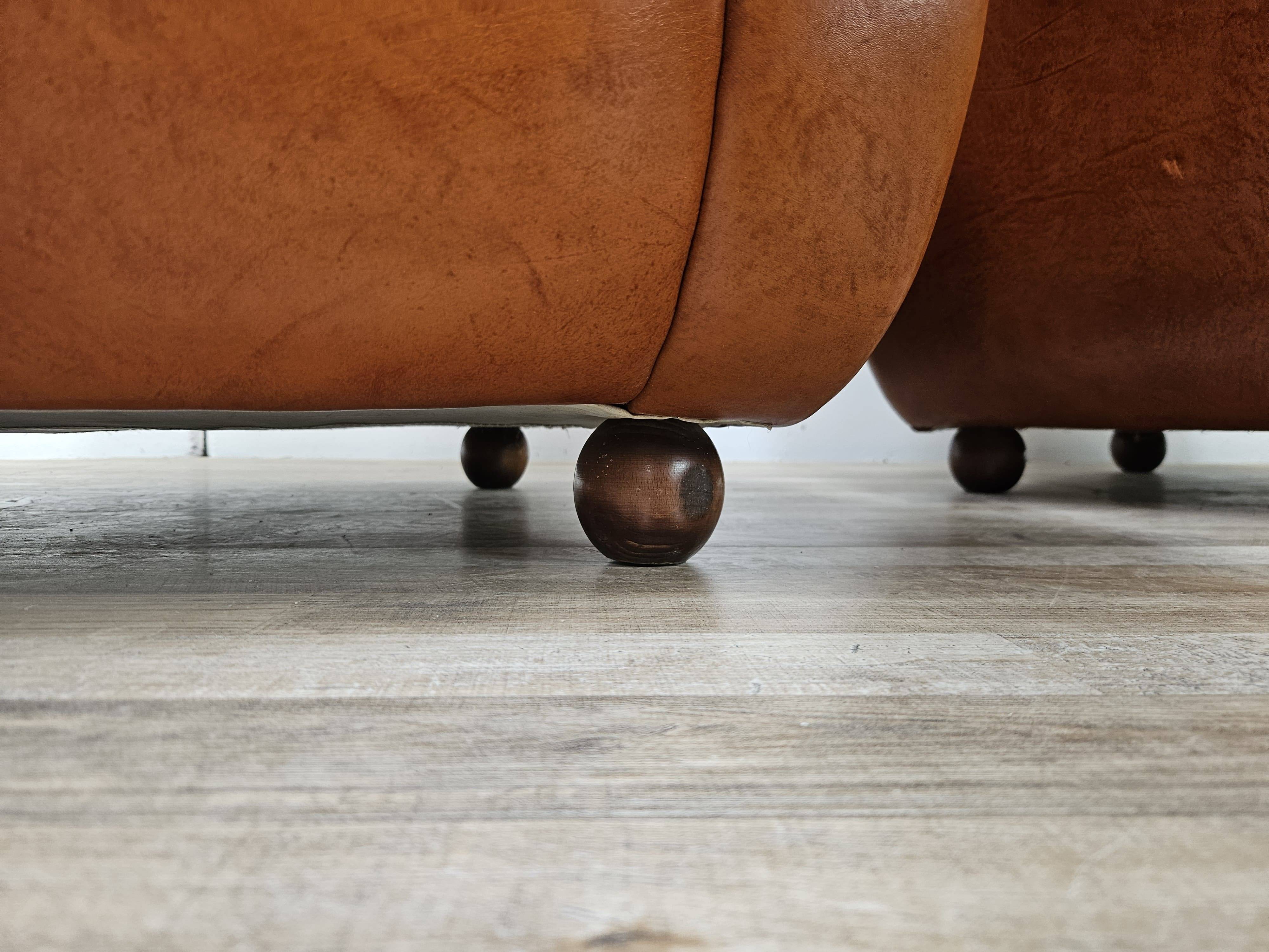 2 fauteuils en cuir cognac, années 1970