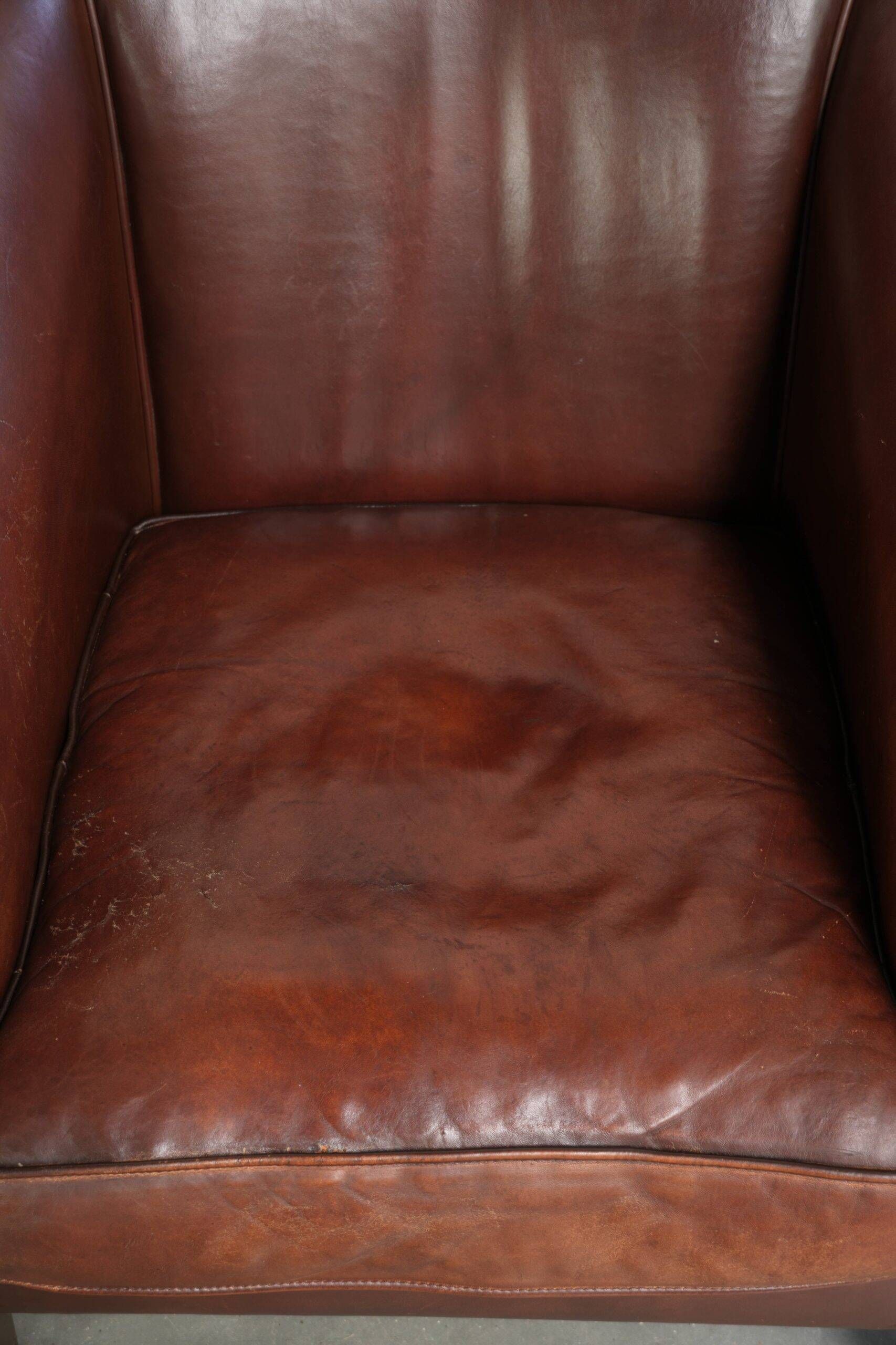 Characterful sheepskin club armchair in a dark cognac colour in English style