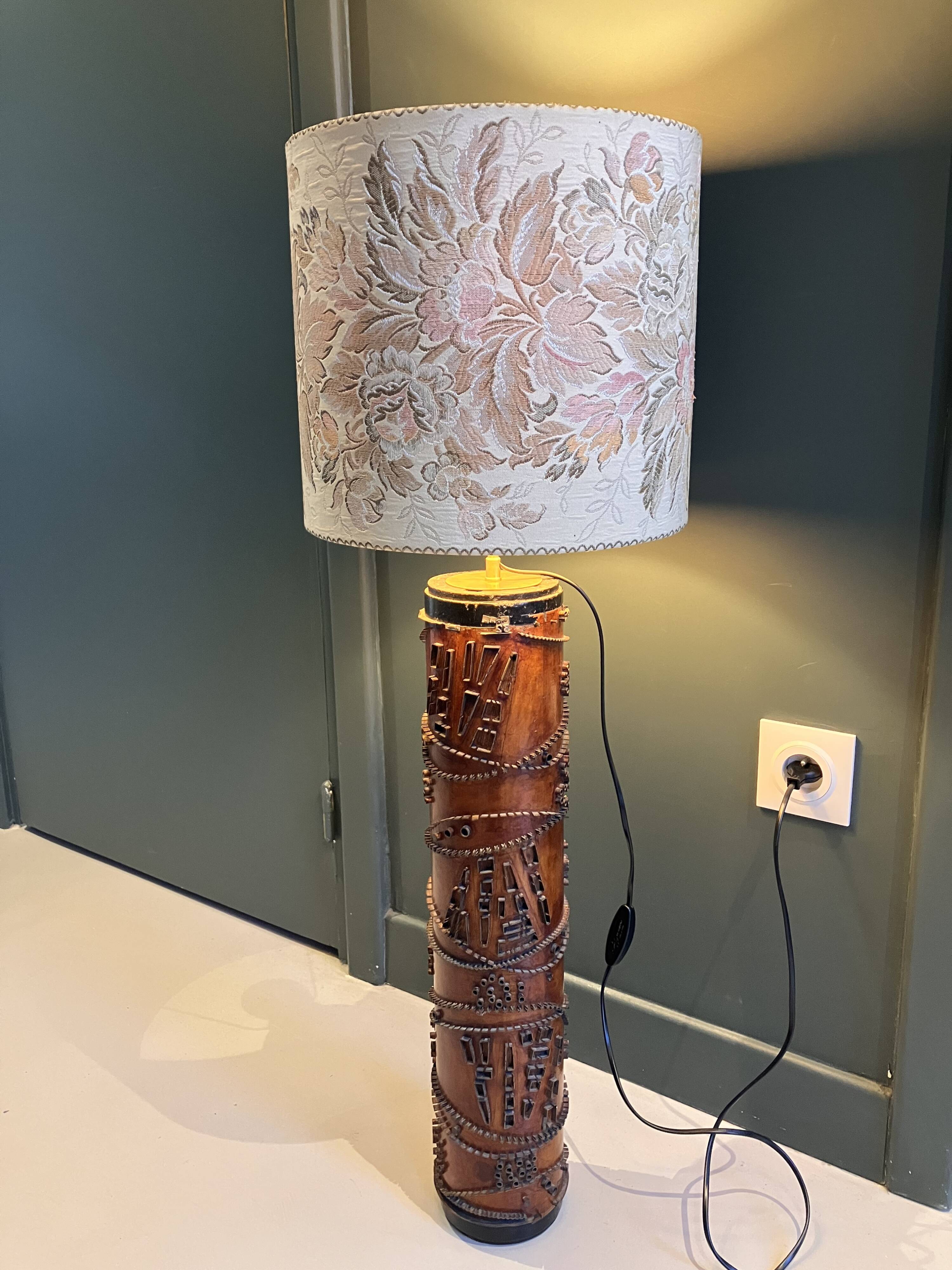 Table lamp with a solid wood printing roll and floral lampshade.