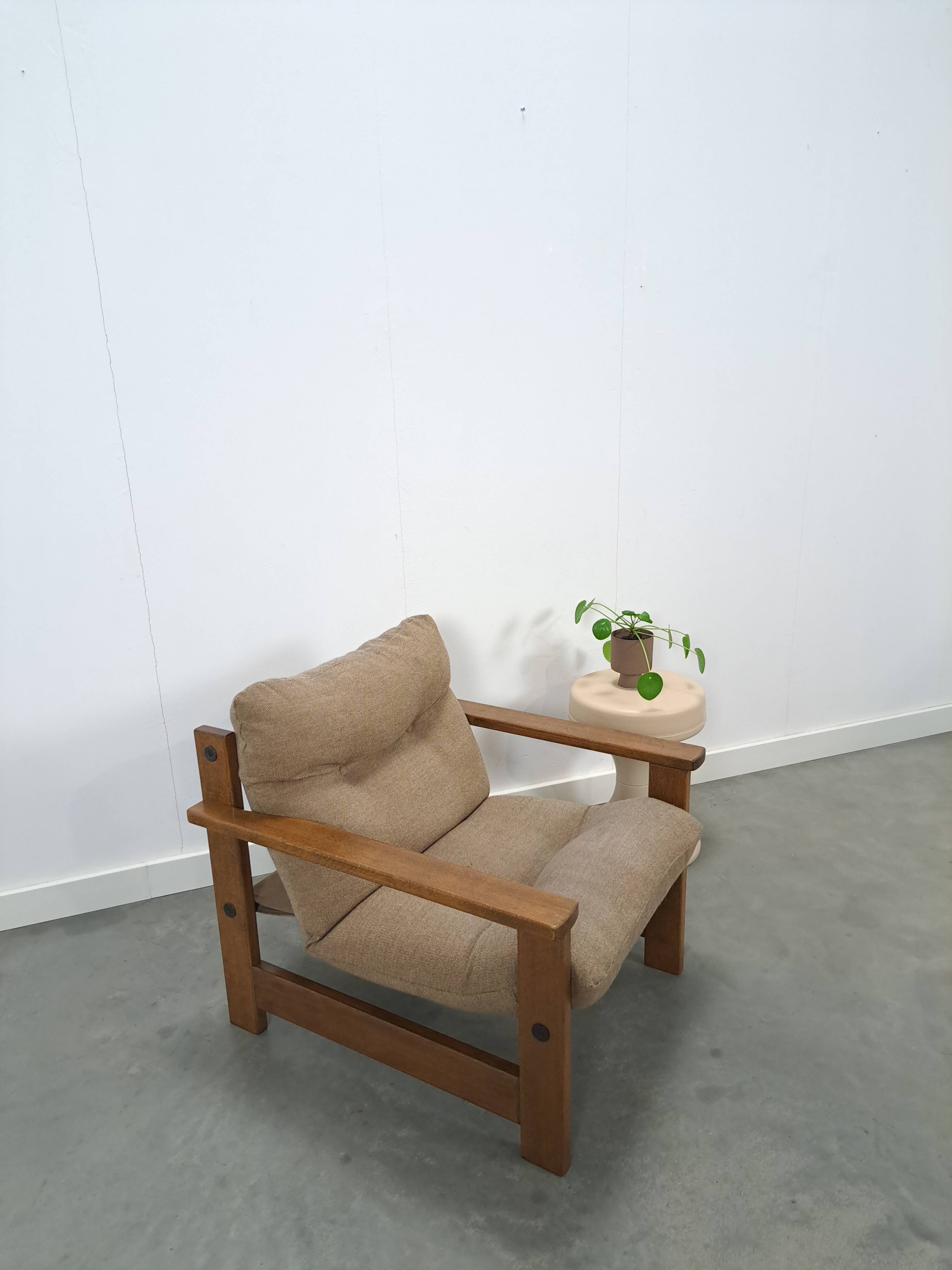 Brown-grey armchair with an oak frame.