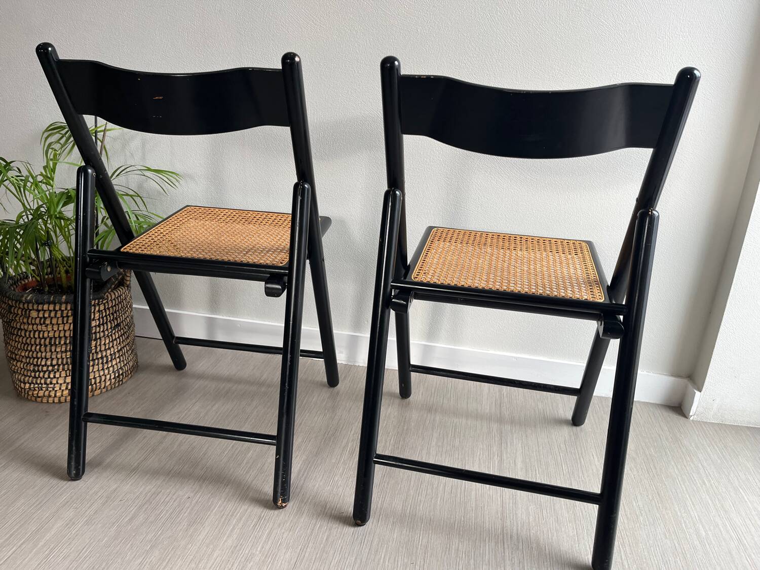 Vintage folding chairs in black wood and cane.