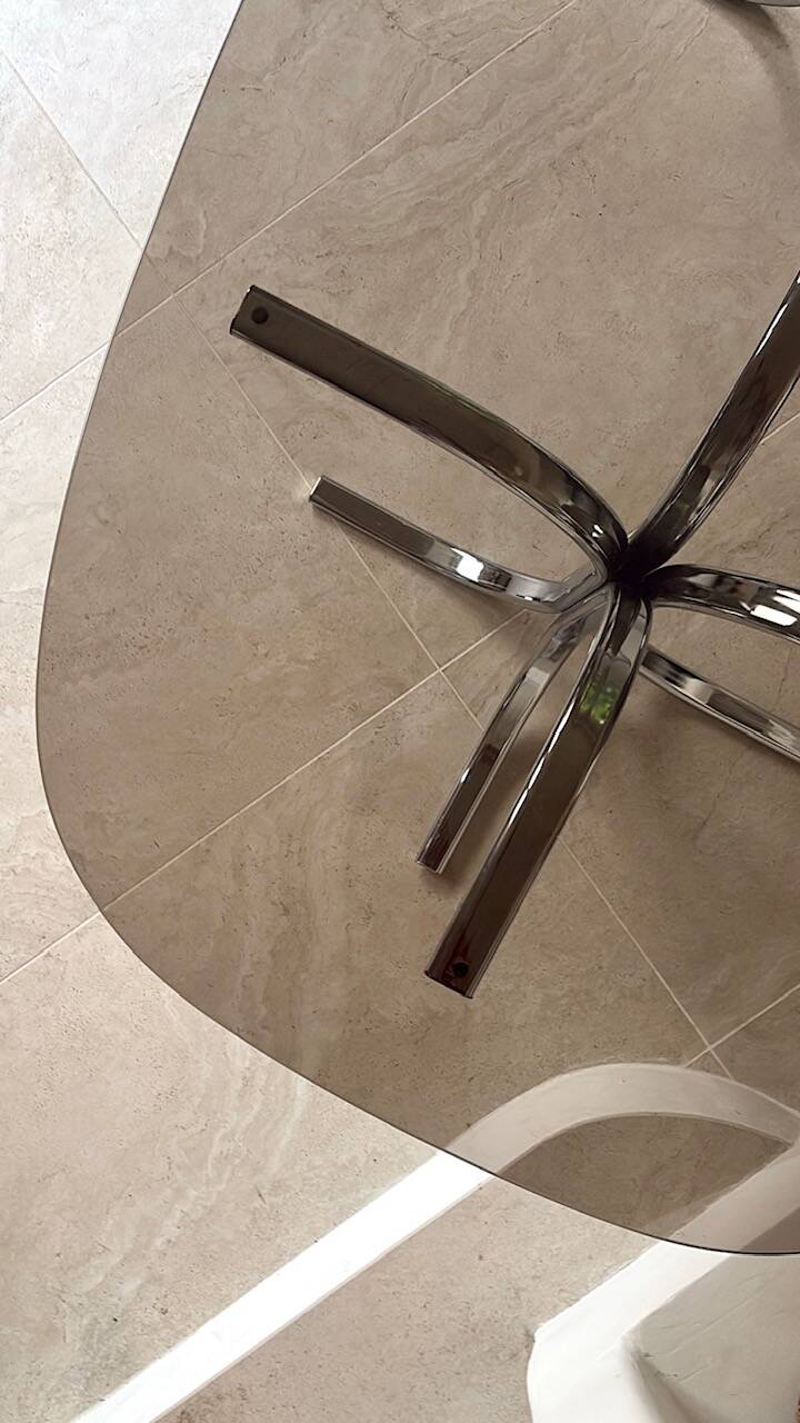 Dining table with stainless steel and smoked glass.