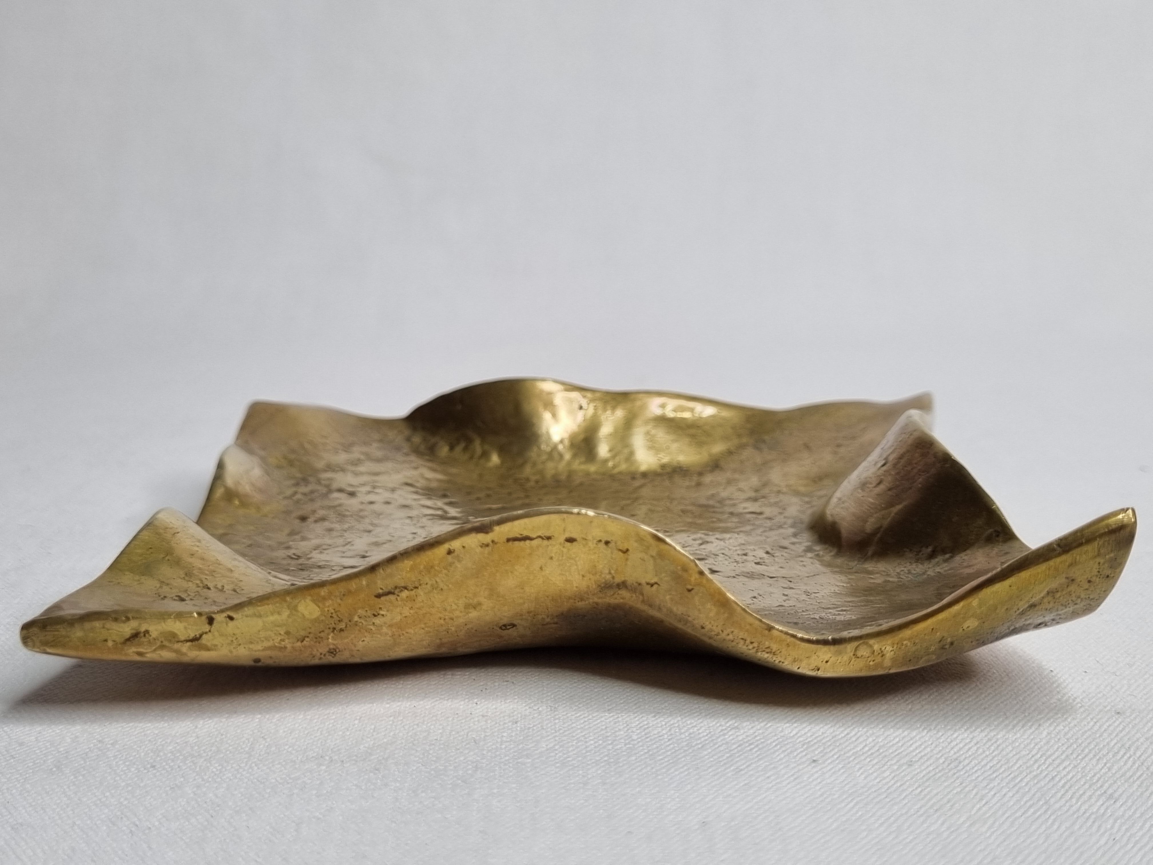Empty pocket in polished brass representing a crumpled paper, signed CJ, 11.5 cm