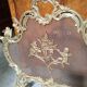 Large gilded bronze fireplace screen decorated with putti and rocaille motifs.
