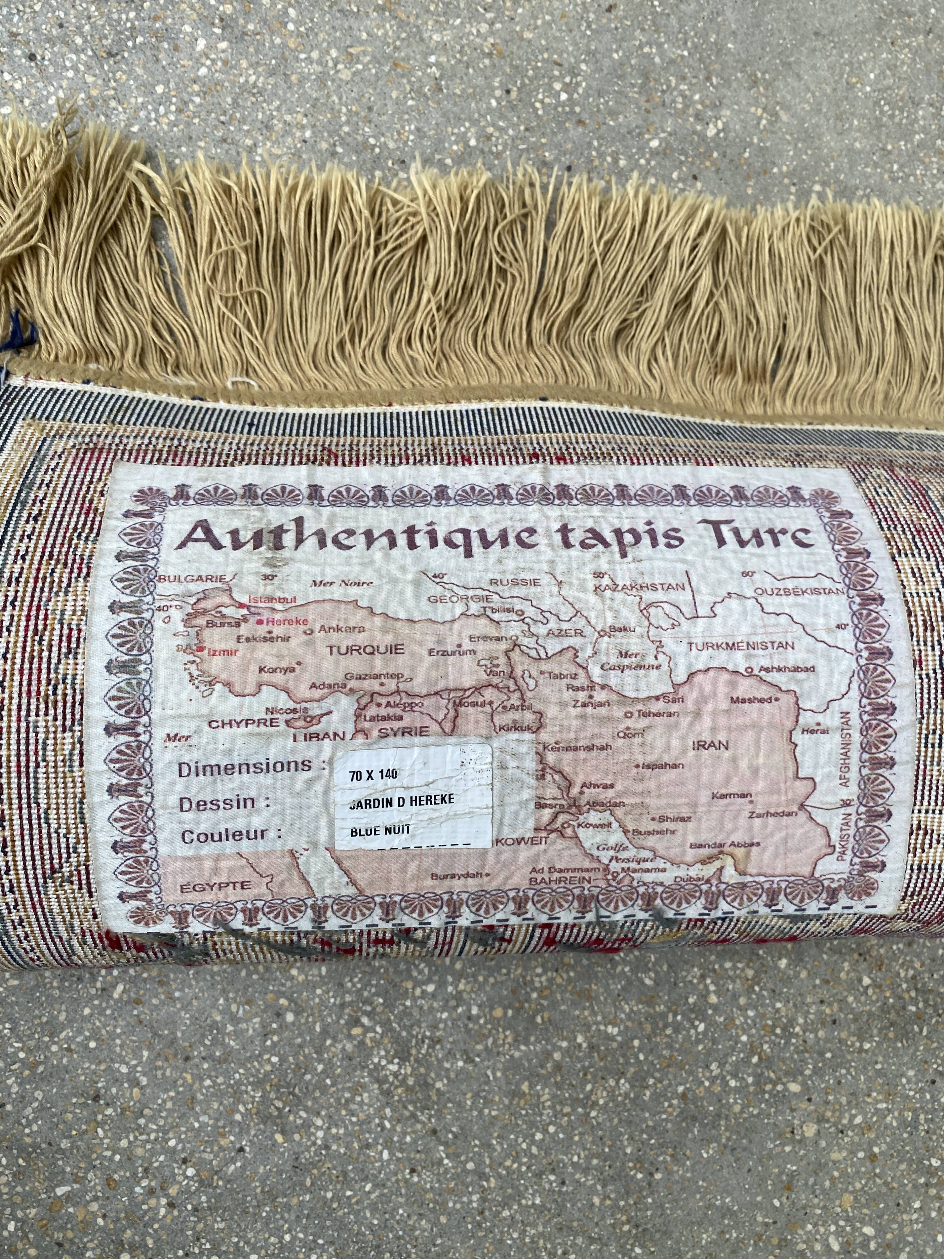 Vintage mechanical Turkish rug with box decoration on a red and navy blue background 139 x 68 cm