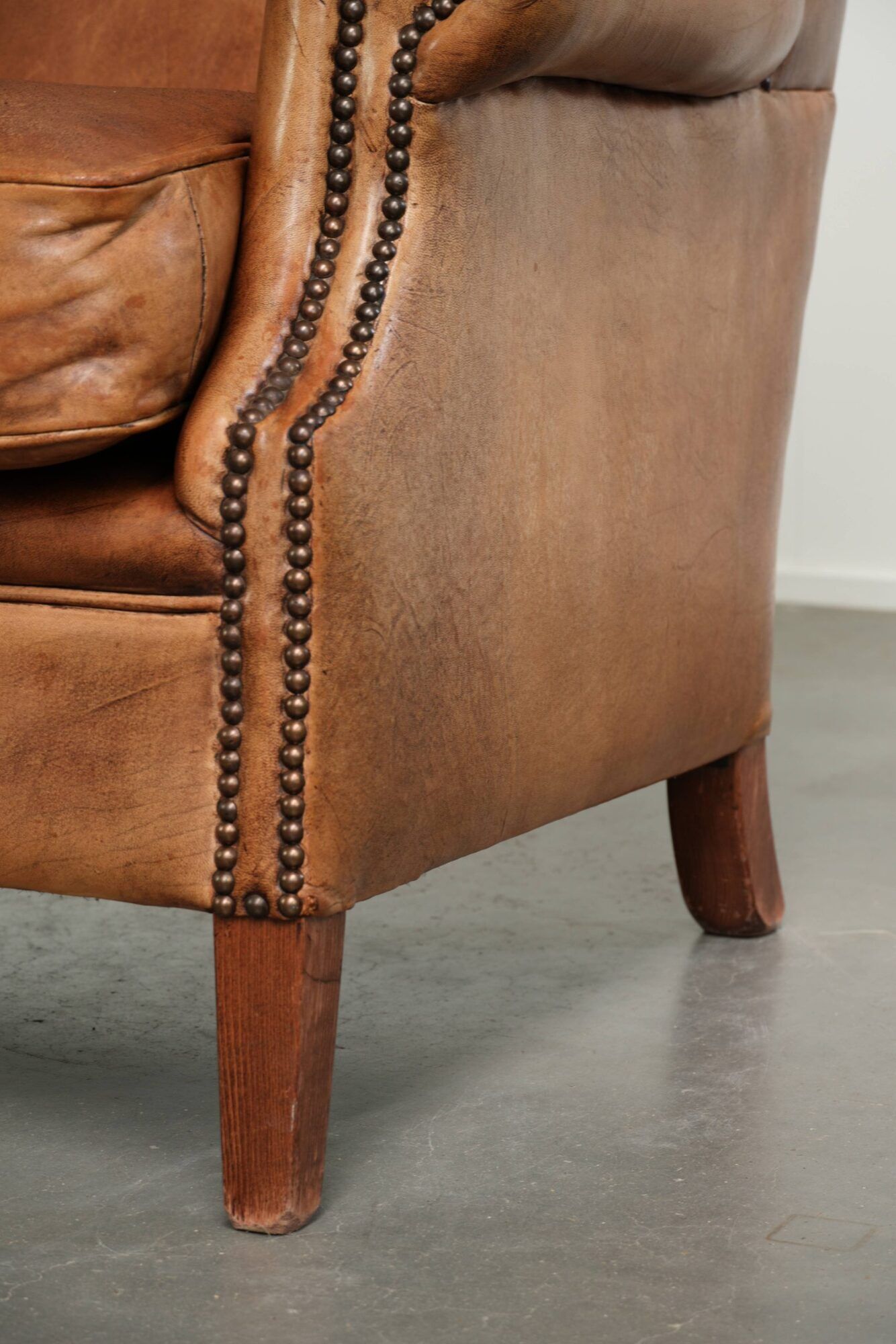 Sheepskin wingback armchair in a light cognac colour in English style