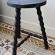 Antique tripod stool in turned wood, painted black – Half-moon seat
