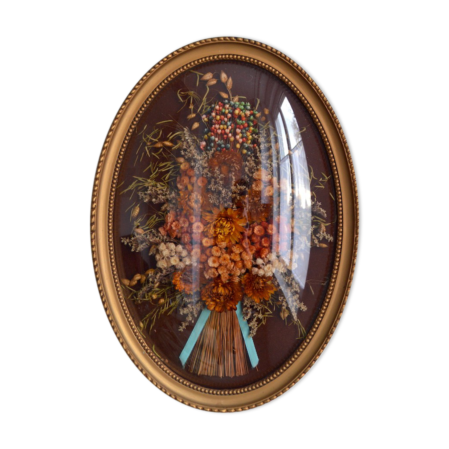 Frame of dried flowers under domed glass