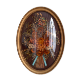 Frame of dried flowers under domed glass