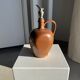 Ancient stoneware jug with a pewter spout.
