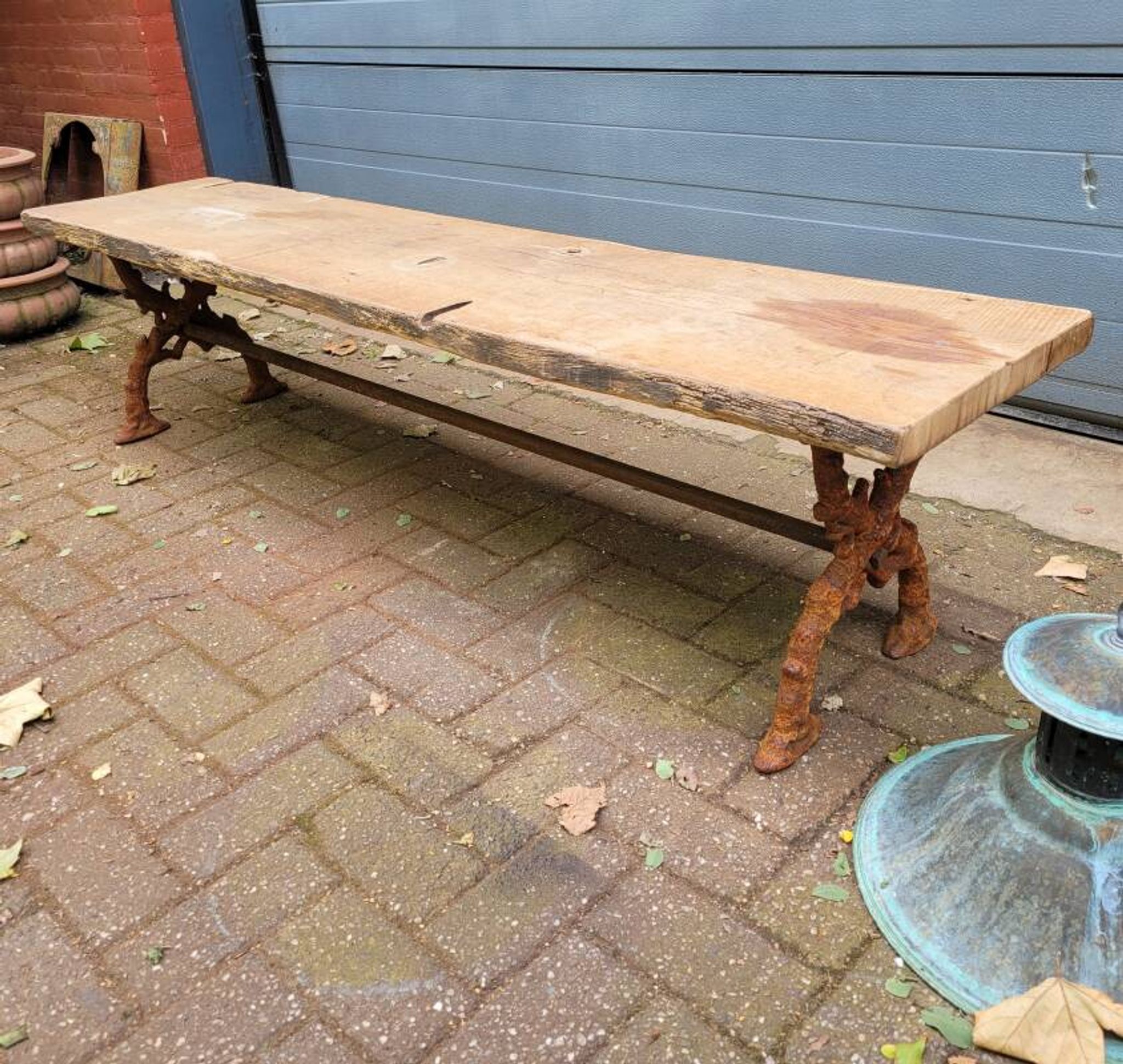 French country-style cast iron garden bench with old barn wood plank.