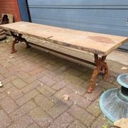 French country-style cast iron garden bench with old barn wood plank.