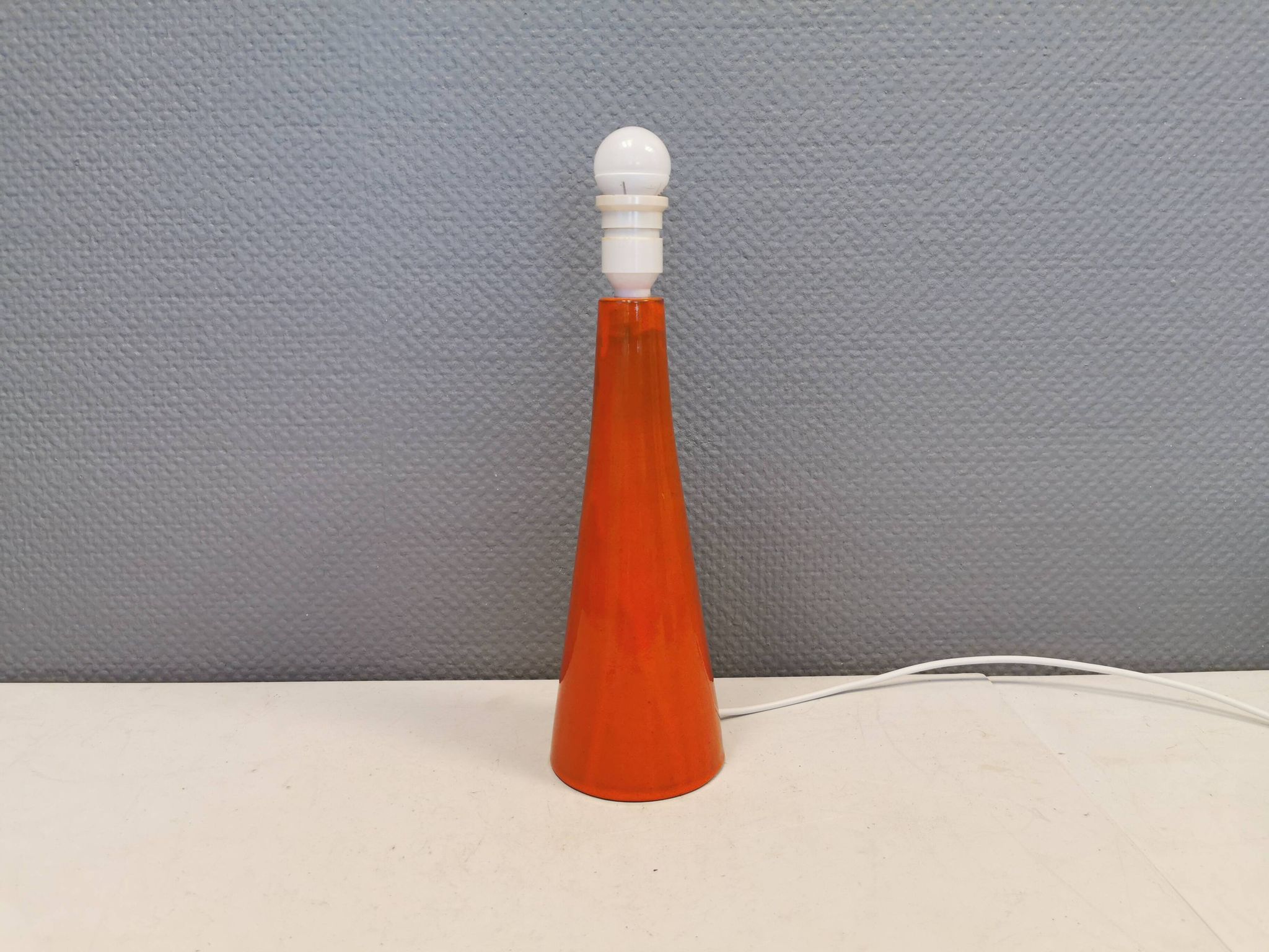 Ceramic table lamp with partial orange glaze.