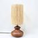 Vintage brutalist lamp with a wooden base and a cylindrical raffia shade.
