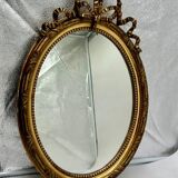 Antique oval gilded mirror with wooden frame and stucco detail