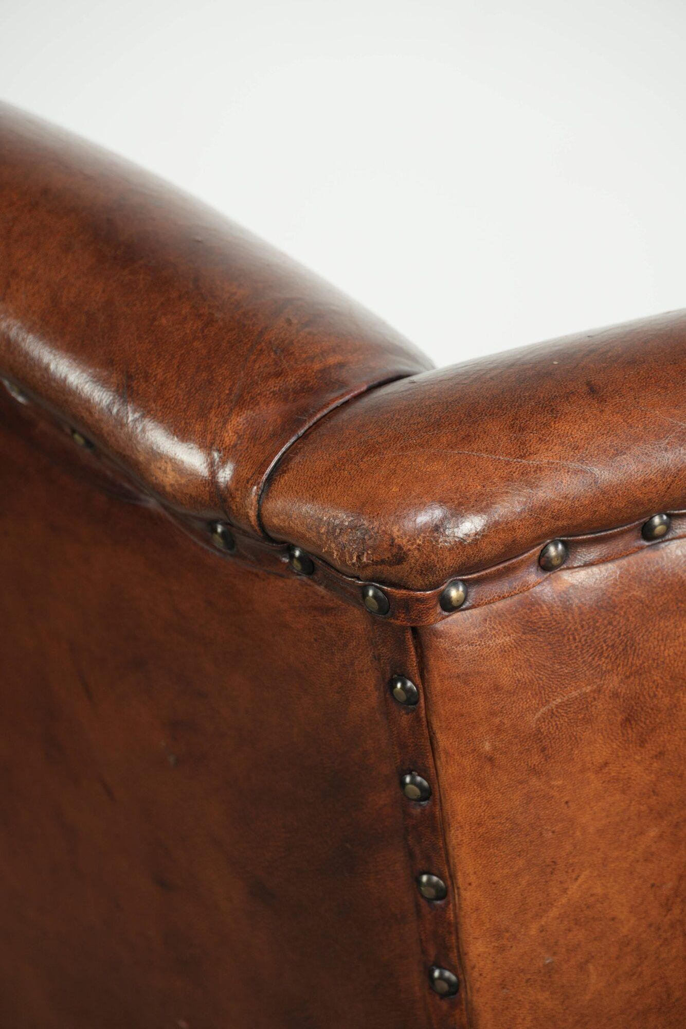 Sheepskin wingback armchair finished with black piping and a correct seat