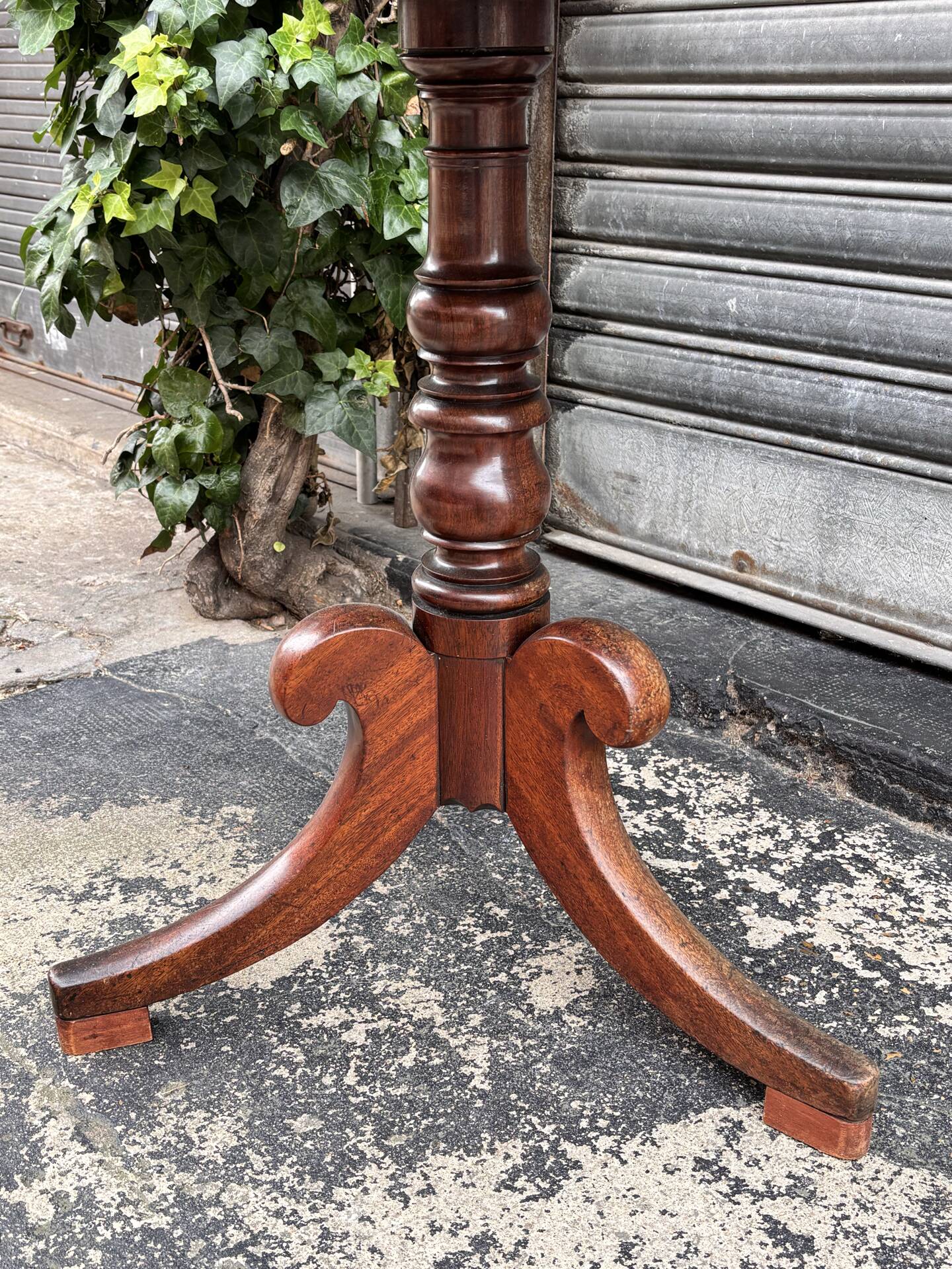 19th-century solid mahogany table with a tilting top and brass mechanism.