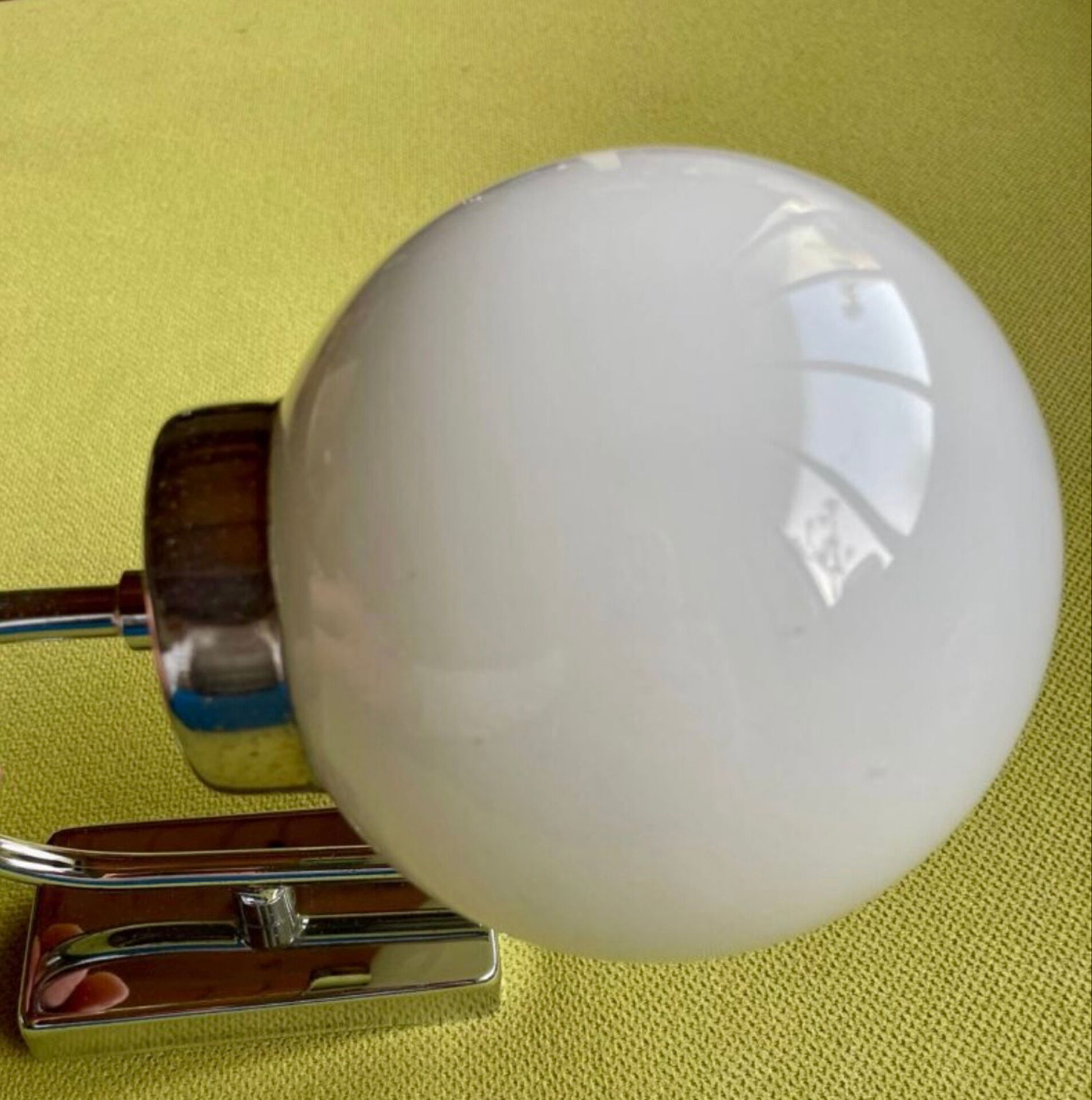 Pair of chrome metal wall lights with white glass globe.