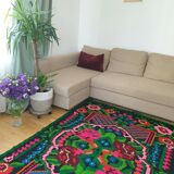 Handwoven colorful Romanian carpet, green and black background with gorgeous colorful flowers