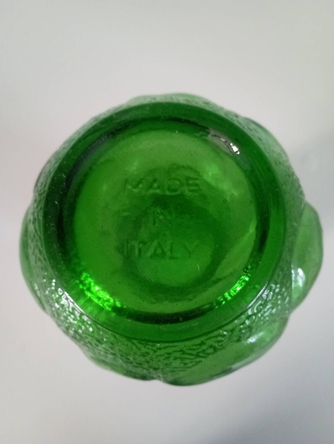 Green glass vase decorated with bunch of grapes and fruits