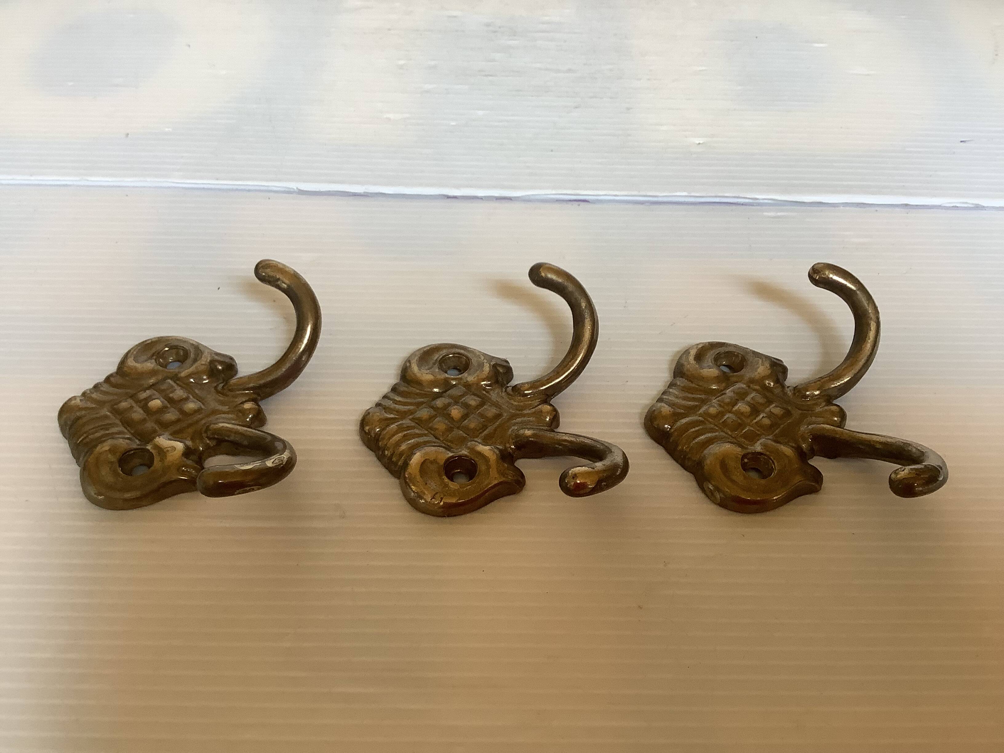 Three double brass coat hooks.