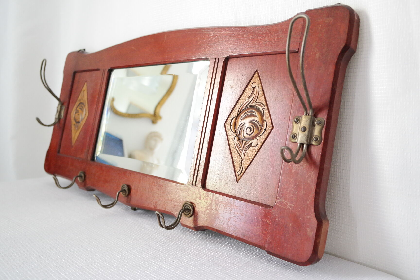 Red wooden wall-mounted coat rack and Art Deco mirror