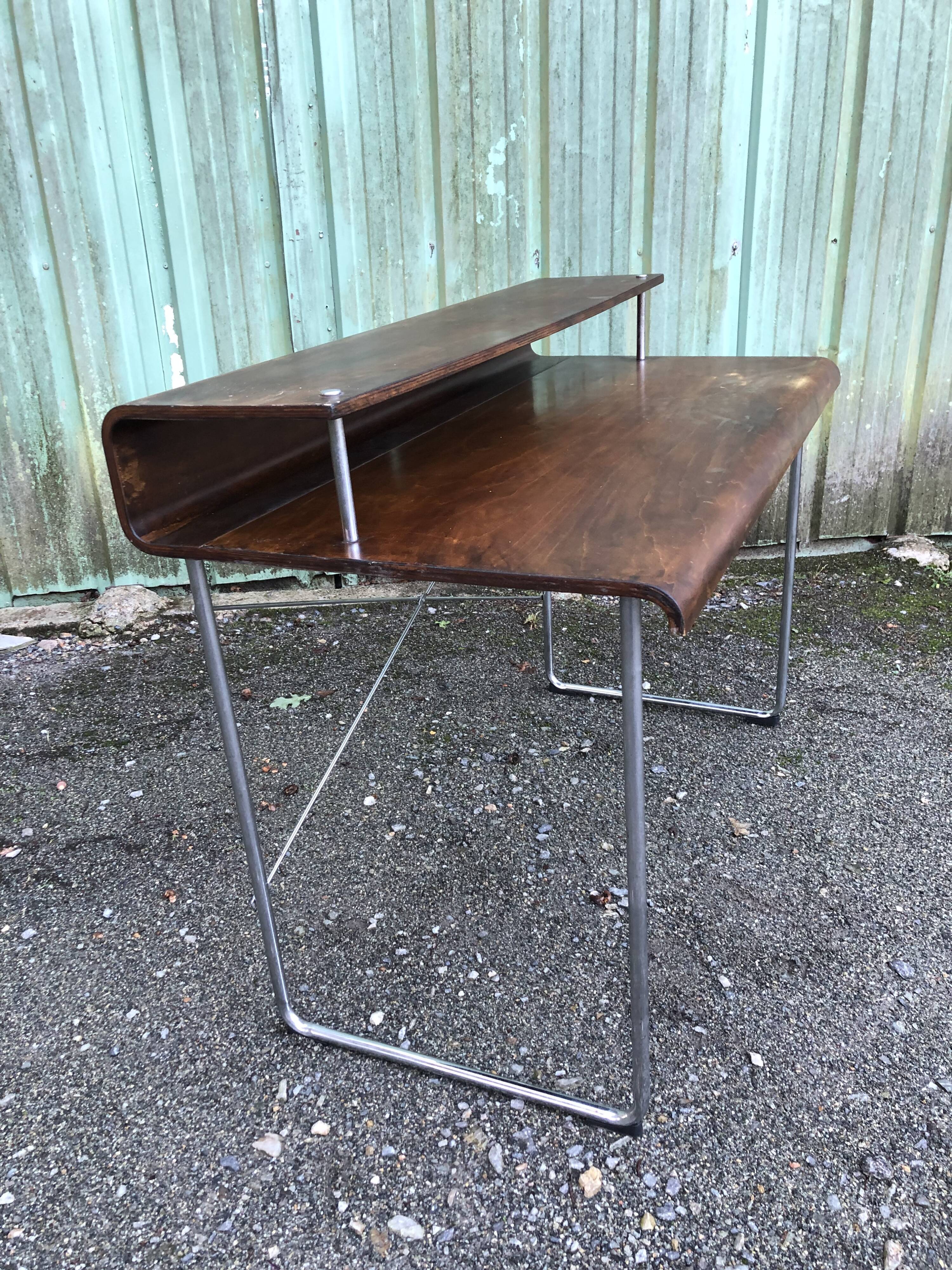 Design desk in formed glued laminated wood with chrome tubular base.