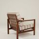 Fauteuil vintage avec des coussins en tissu naturel rayé.